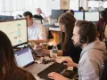 Equipo trabajando en oficina. Se preguntan cuanto cobra un periodista por su labor.