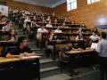 Estudiantes en un aula universitaria, atentos a una clase sobre relaciones internacionales.