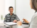 Hombre sonriente en entrevista para una **formación en centros de trabajo**.