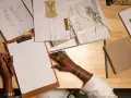 Manos dibujando bocetos de moda, inspirada para estudiar diseño de moda.