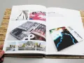 Un portfolio de diseño gráfico muestra una revista abierta con imágenes de arquitectura y arte abstracto, y un folleto de "Detroit rock city".
