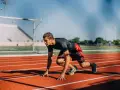 Atleta en posición de salida en pista de atletismo. ¿Cuánto cobra un profesor de educación física?