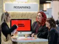 Tres mujeres conversan en un stand de ROSAPARKS, un evento de marketing en Barcelona.