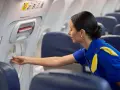 Una azafata de vuelo revisa un compartimento en el avión.