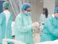 Estudiantes de enfermería en universidades privadas practican en un entorno clínico, vestidas con batas y mascarillas.