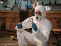 Un forense con traje protector examina una evidencia. Las salidas de la criminología son variadas: investigación, análisis, justicia.
