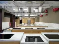 Cocina moderna equipada para una carrera de gastronomía, con encimeras de mármol, placas de inducción y campanas extractoras.