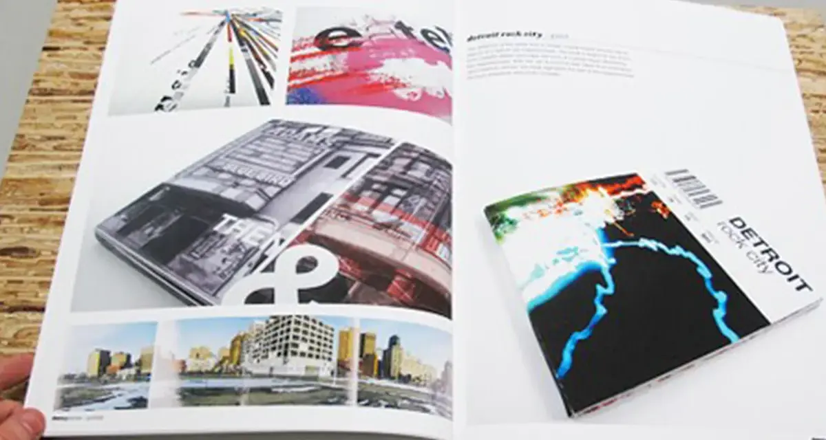 Un portfolio de diseño gráfico muestra una revista abierta con imágenes de arquitectura y arte abstracto, y un folleto de "Detroit rock city".