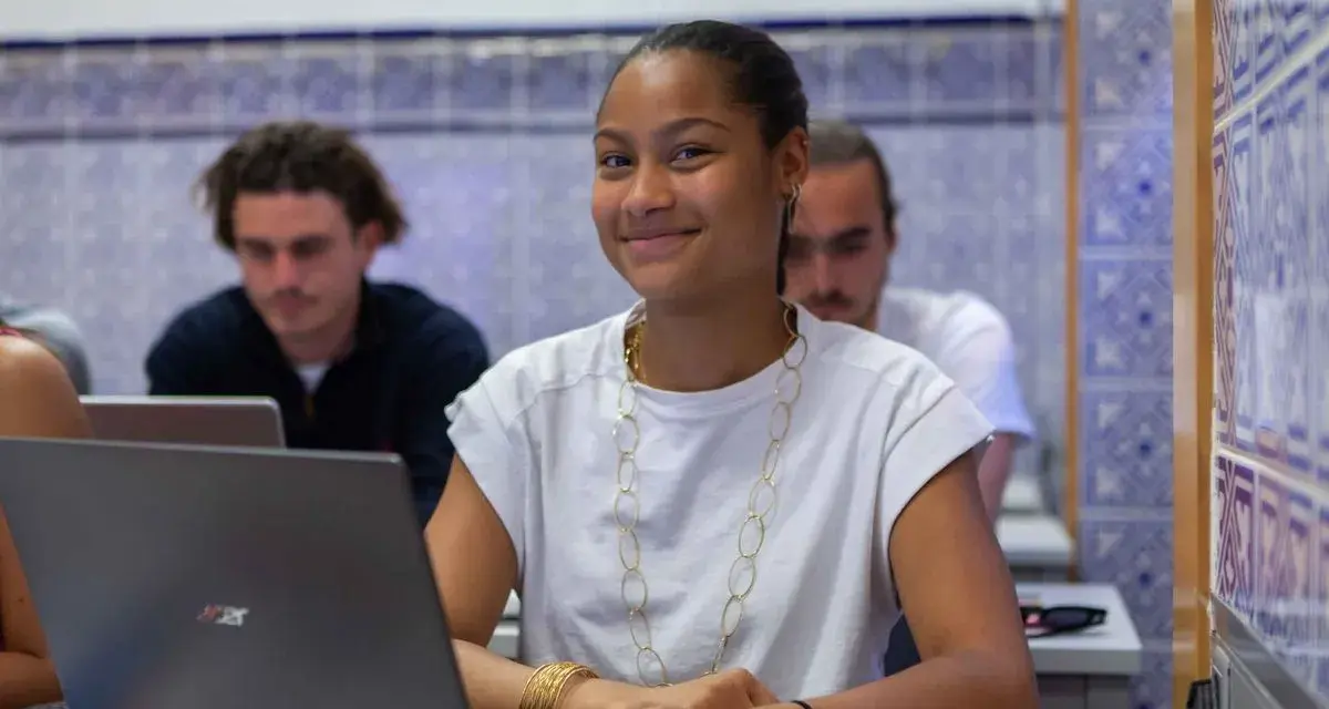 Estudiante sonriente en clase, preparándose para su doble grado derecho y relaciones internacionales.