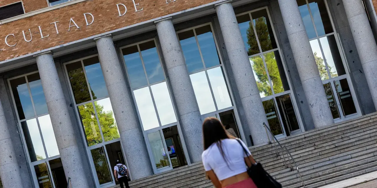 Fachada de la Facultad de Medicina, con estudiantes subiendo escaleras. Un futuro médico se dirige a una de las universidades privadas de medicina.