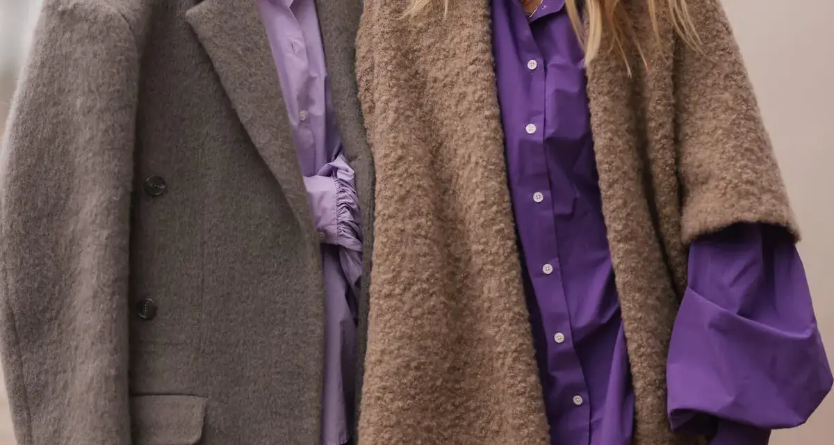 Dos personas con abrigos y camisas moradas. Un ejemplo de que es la fast fashion: ropa barata y de moda rápida.