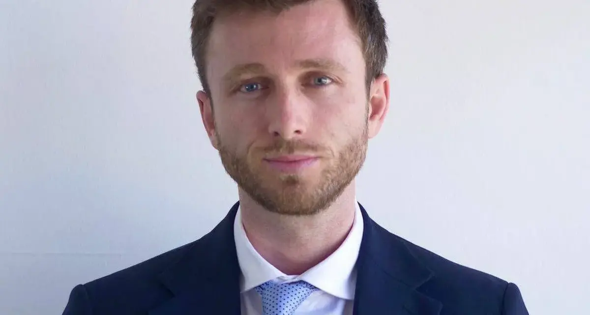 Hombre con traje azul y corbata de puntos. ¿Cuánto cobra un abogado laboralista?