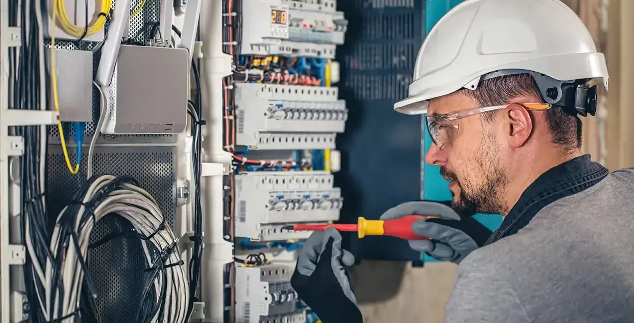 Electricista trabajando en un cuadro eléctrico. El salario de un electricista en España varía según experiencia y ubicación.