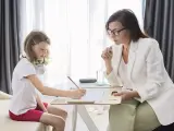 Psicóloga atenta a una niña que dibuja. La sesión es parte de la terapia infantil, y la pregunta de cuánto cobra un psicólogo en España es clave para acceder a estos servicios.
