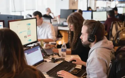 Equipo trabajando en oficina. Se preguntan cuanto cobra un periodista por su labor.