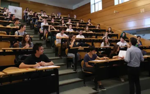Estudiantes en un aula universitaria, atentos a una clase sobre relaciones internacionales.