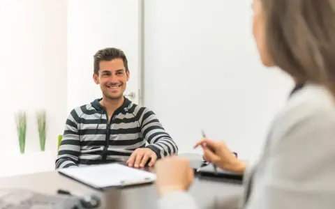 Hombre sonriente en entrevista para una **formación en centros de trabajo**.