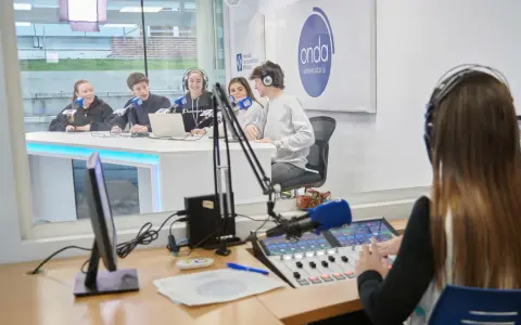 Estudiantes en un estudio de radio, practicando comunicación digital.