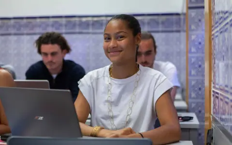 Estudiante sonriente en clase, preparándose para su doble grado derecho y relaciones internacionales.