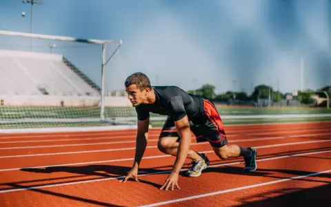 Atleta en posición de salida en pista de atletismo. ¿Cuánto cobra un profesor de educación física?