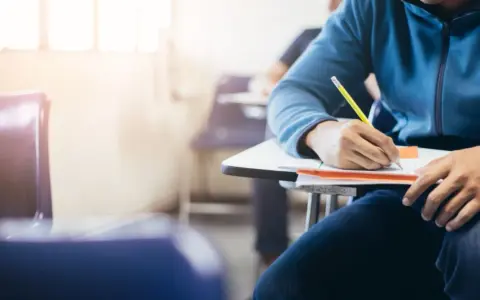 Estudiante concentrado en un examen, quizás preparándose para una de las carreras más difíciles de España.