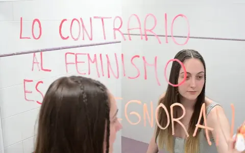 Joven reflexiona ante el espejo, escribiendo "Lo contrario al feminismo es ignorancia". Un mensaje para quienes estudian técnico superior en promoción de igualdad de género online.