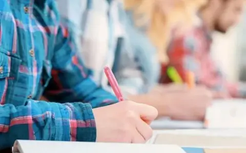 Estudiantes concentrados escribiendo en sus cuadernos. Un ambiente ideal de cafyd donde estudiar y aprender.