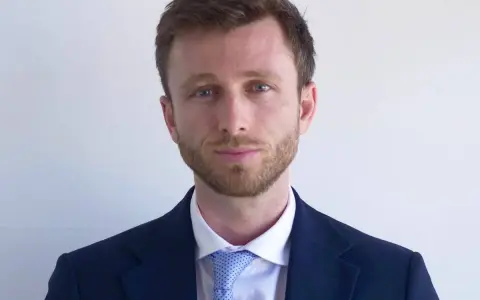 Hombre con traje azul y corbata de puntos. ¿Cuánto cobra un abogado laboralista?