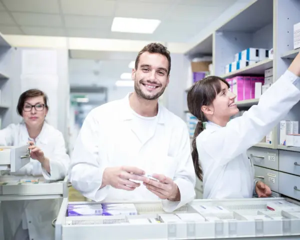 Farmacéuticos sonríen en Barcelona, preparándose para sus grados medios.