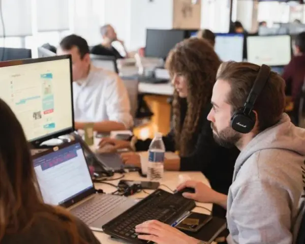Equipo trabajando en oficina. Se preguntan cuanto cobra un periodista por su labor.