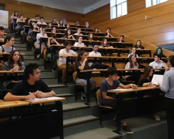 Estudiantes en un aula universitaria, atentos a una clase sobre relaciones internacionales.