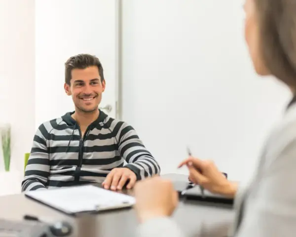Hombre sonriente en entrevista para una **formación en centros de trabajo**.