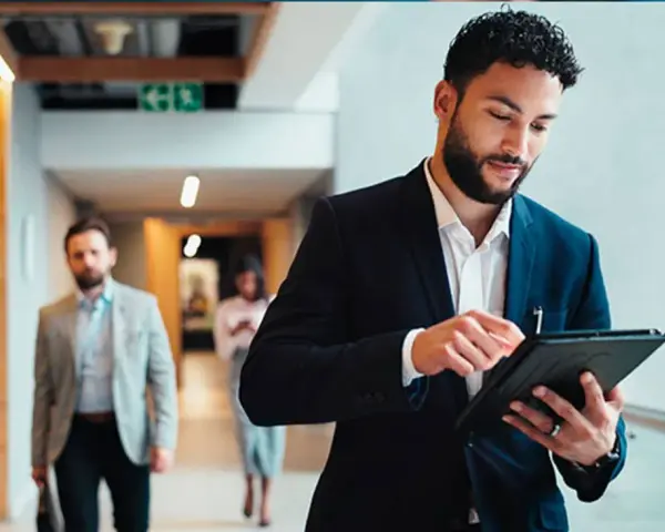 Hombre de negocios revisa su tablet, preparándose para sus dobles grados con relaciones internacionales.