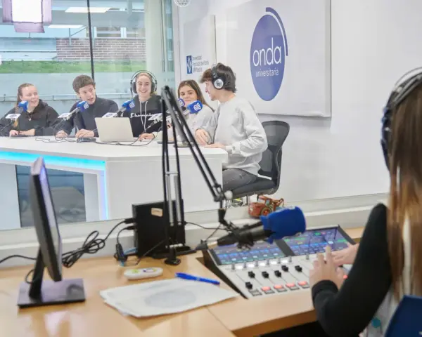 Estudiantes en un estudio de radio, practicando comunicación digital.