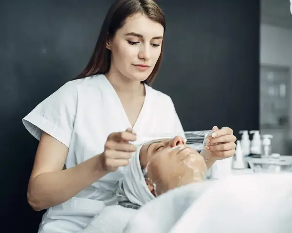 Esteticista aplica tratamiento facial. ¿Cuánto gana una esteticista en España? Descubre el potencial de esta profesión.