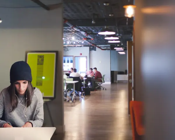 Jóvenes colaboran en la formación de centros de trabajo, un espacio moderno con luz tenue y ambiente de estudio.
