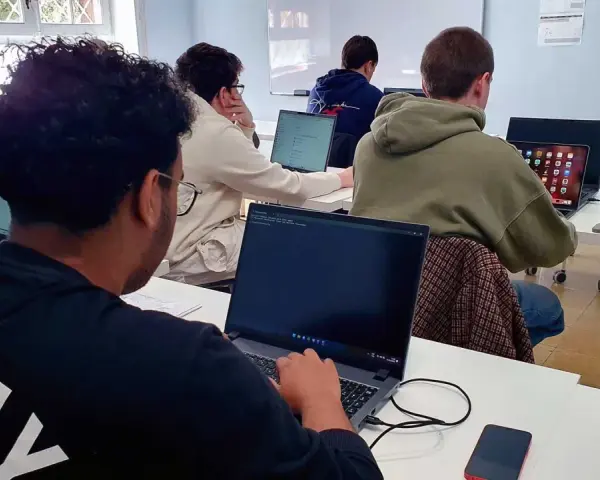 Estudiantes de **grado medio informática** concentrados frente a sus ordenadores en un aula.