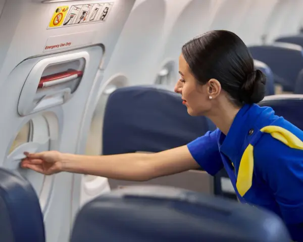 Una azafata de vuelo revisa un compartimento en el avión.