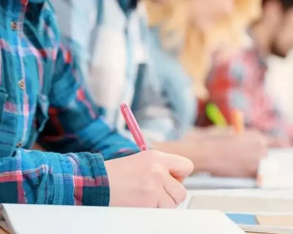 Estudiantes concentrados escribiendo en sus cuadernos. Un ambiente ideal de cafyd donde estudiar y aprender.