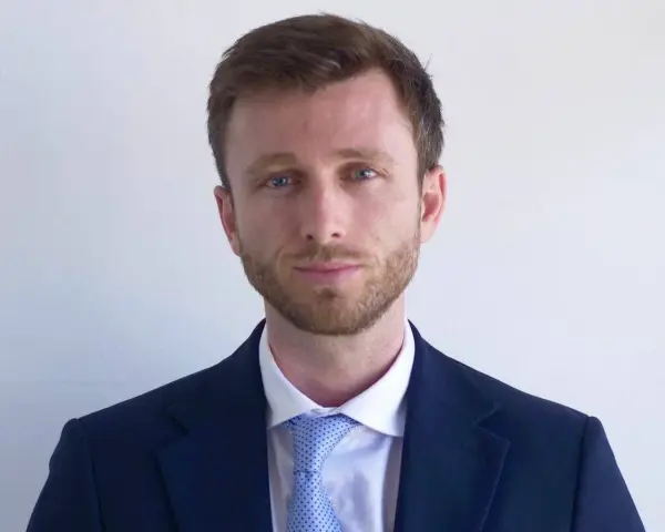 Hombre con traje azul y corbata de puntos. ¿Cuánto cobra un abogado laboralista?