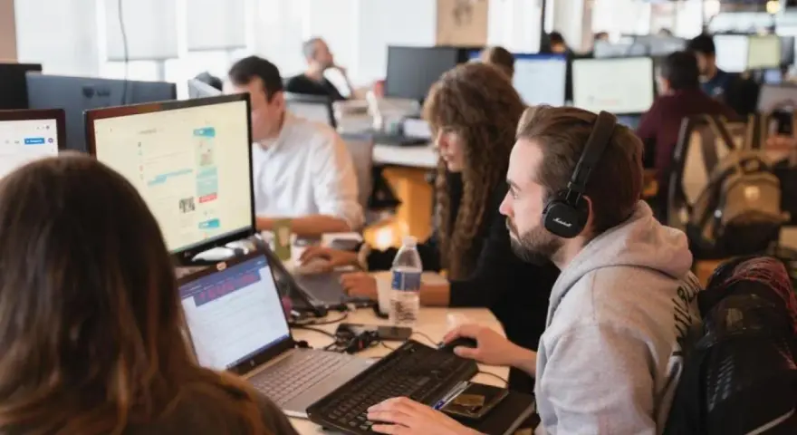 Equipo trabajando en oficina. Se preguntan cuanto cobra un periodista por su labor.