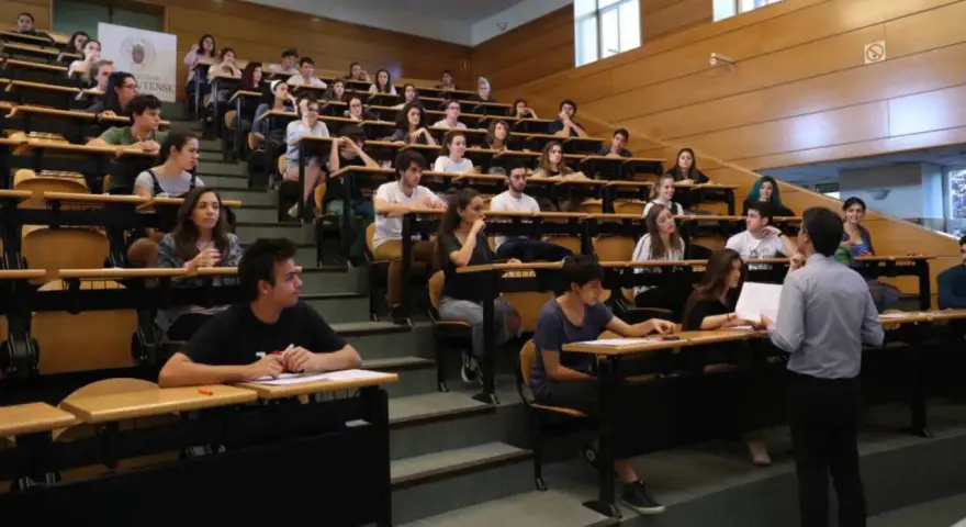 Estudiantes en un aula universitaria, atentos a una clase sobre relaciones internacionales.
