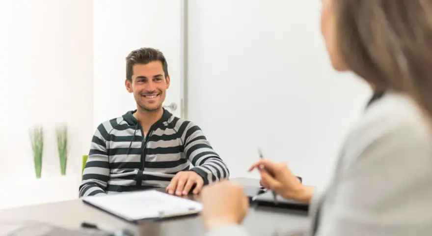 Hombre sonriente en entrevista para una **formación en centros de trabajo**.