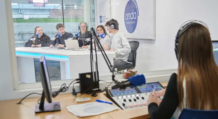 Estudiantes en un estudio de radio, practicando comunicación digital.