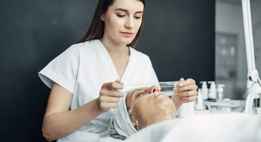 Esteticista aplica tratamiento facial. ¿Cuánto gana una esteticista en España? Descubre el potencial de esta profesión.