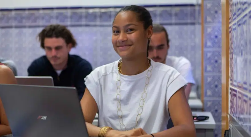 Estudiante sonriente en clase, preparándose para su doble grado derecho y relaciones internacionales.