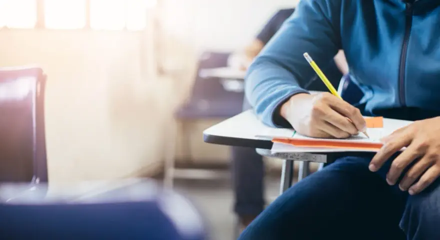 Estudiante concentrado en un examen, quizás preparándose para una de las carreras más difíciles de España.