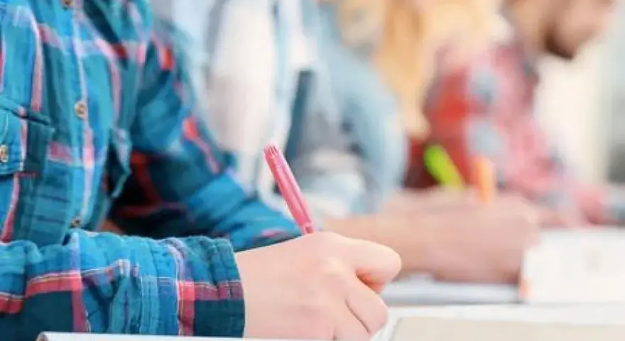 Estudiantes concentrados escribiendo en sus cuadernos. Un ambiente ideal de cafyd donde estudiar y aprender.