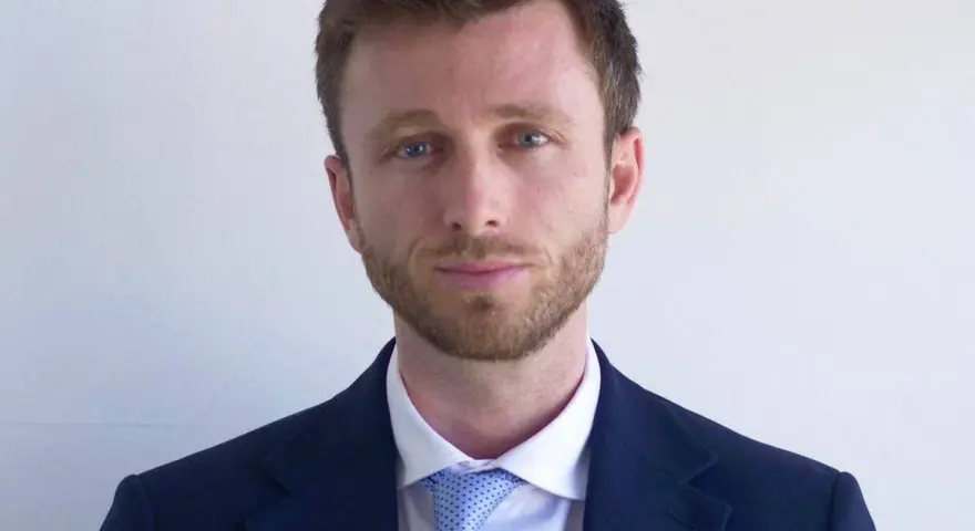 Hombre con traje azul y corbata de puntos. ¿Cuánto cobra un abogado laboralista?