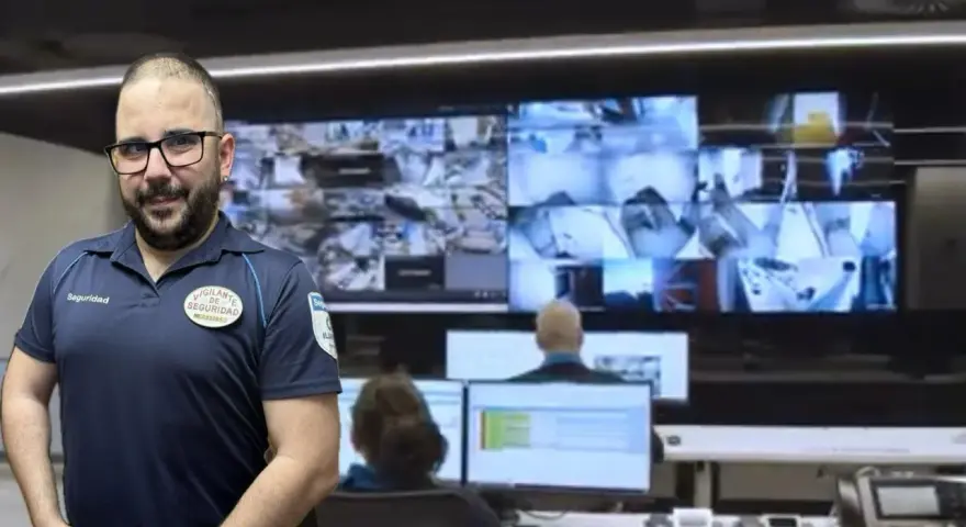 Vigilante de seguridad con certificado de discapacidad, sonriendo ante cámaras de vigilancia.